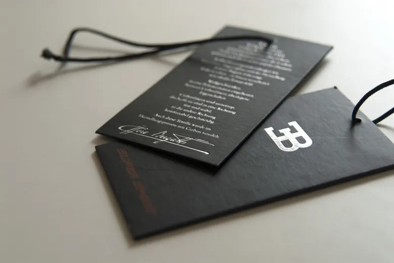 Etiquetas de cartão preto com impressão a branco e cordão preto